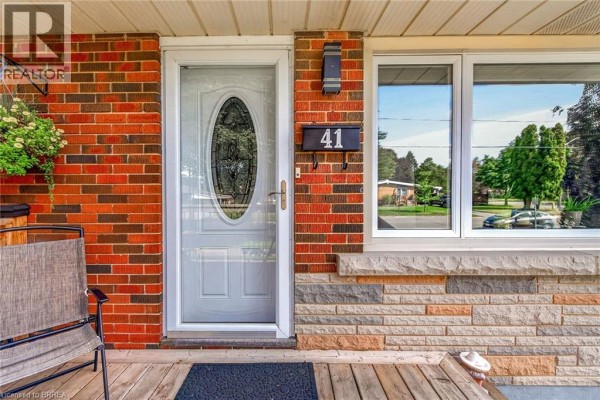 Front door with an oval glass insert, surrounded by brick and stone facade. - 41 Kensington Avenue, Brantford