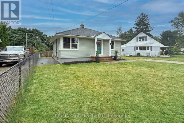 Exterior view from the side of the bungalow showing the chain-link fence and lawn. - 41 Kensington Street, Woodstock