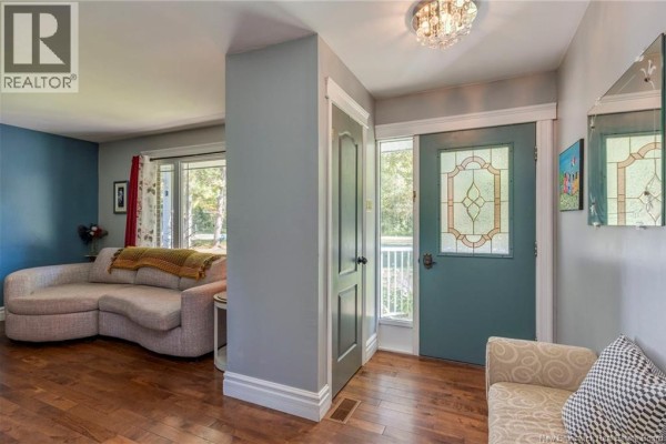 Interior foyer with gray walls, a teal front door with stained glass, and a sectional sofa. - 41 Manuel, Baie Sainte Anne