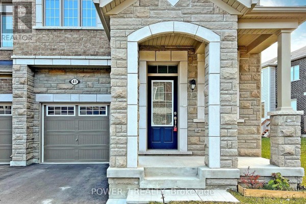 Close-up of the stone facade, archway, and blue front door of a townhouse at 41 Ness Drive. - 41 Ness Drive, Richmond Hill