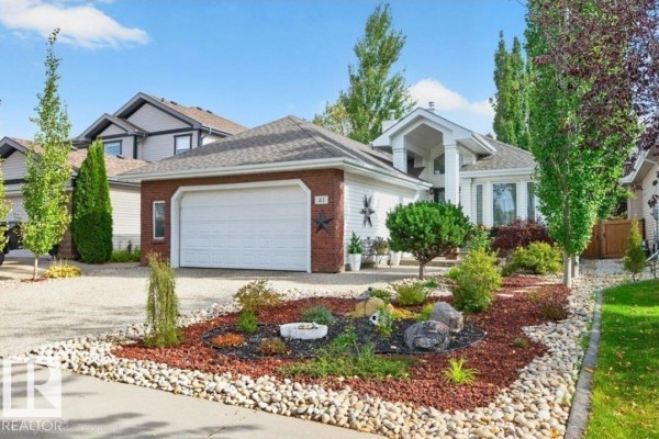 Front view of the house with a gravel driveway and decorative rock garden bed. - 41 North Ridge Dr, St  Albert