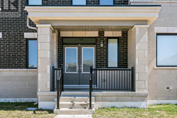 Close-up of the townhouse front entrance with double glass doors, porch light, and stone pillars. - 41 Robert Eaton Avenue, Markham