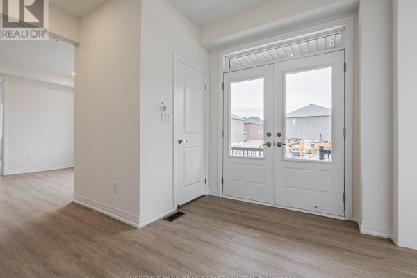 Interior view of a bright entryway with double glass doors, light wood floors, and a closet. - 41 Robert Eaton Avenue, Markham
