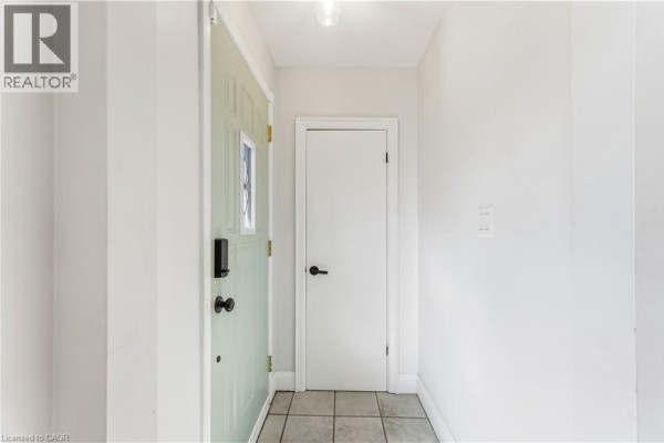 Interior view of the main floor entryway with a light green door and beige tiled floor. - 41 Sharon Avenue Unit# Main Floor, Hamilton