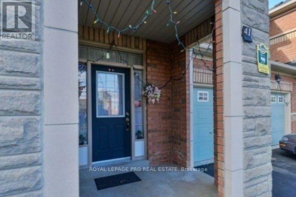 Close-up view of a dark blue front door with a glass insert, flanked by brick and stone pillars. - 41 Unionville Crescent, Brampton