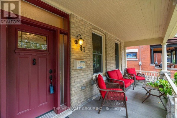 Close-up of the front porch entrance with a red door, house number 41, and seating. - 41 Victor Street, London South