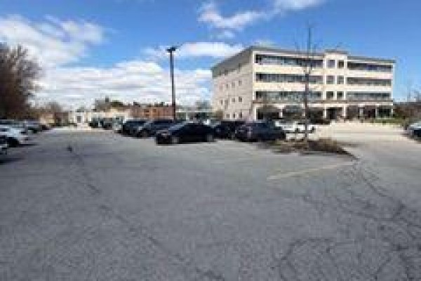 Aerial view of a commercial building and surrounding parking lot with trees. - 410 - 170 The Donway West, Toronto