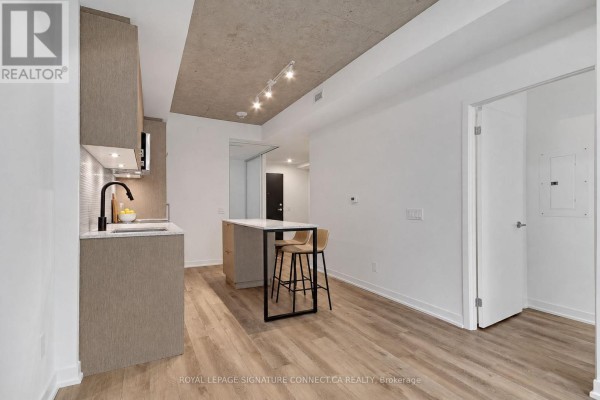 Empty room with white walls, light wood floors, and a large white sliding closet door. - 410 - 1808 St Clair Avenue, Toronto