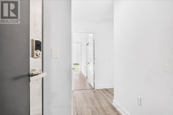 Interior view of an apartment entrance hallway with a modern smart lock and a doorway leading to other rooms. - 410 - 375 Sea Ray Avenue, Innisfil