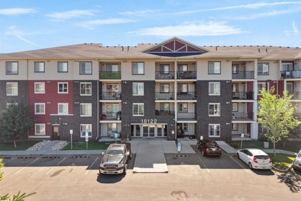 Exterior view of a multi-story apartment building with balconies and parking. - #410 18122 77 St Nw, Edmonton