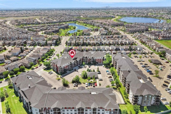 Aerial view of apartment buildings surrounded by suburban homes and a pond. - #410 18122 77 St Nw, Edmonton