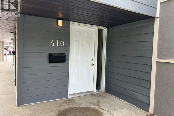 Close-up of the front entrance to unit 410, featuring a white door and black mailbox. - 410 510 Prairie Avenue, Saskatoon