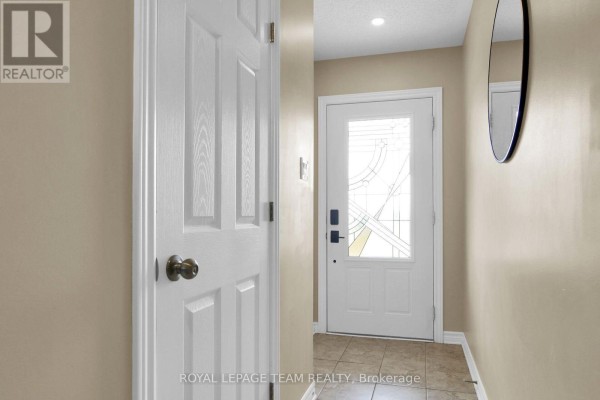 Interior view of a hallway with beige walls, tiled floor, and a white door on the left. - 410 Ann Street, Mississippi Mills