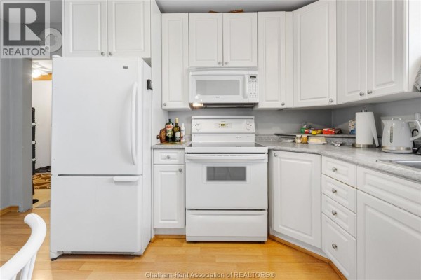 Bedroom with wooden furniture and hardwood floors - 410 Mcnaughton Avenue East Chatham