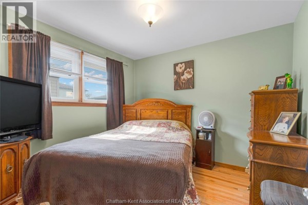 Kitchen with white cabinets, white appliances, and a dining table - 410 Mcnaughton Avenue East Chatham