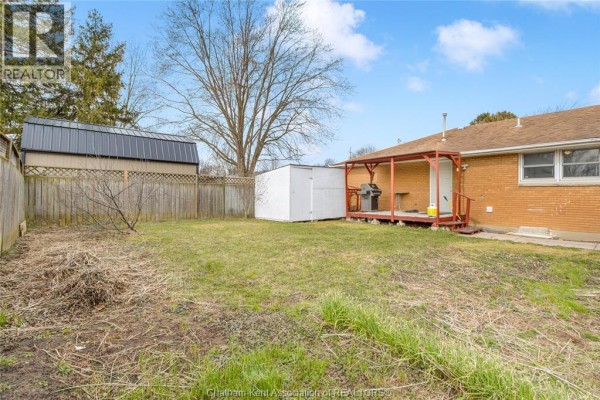 Aerial view of a house with driveway, lawn, sheds, fenced yard, and covered pool - 410 Mcnaughton Avenue East Chatham
