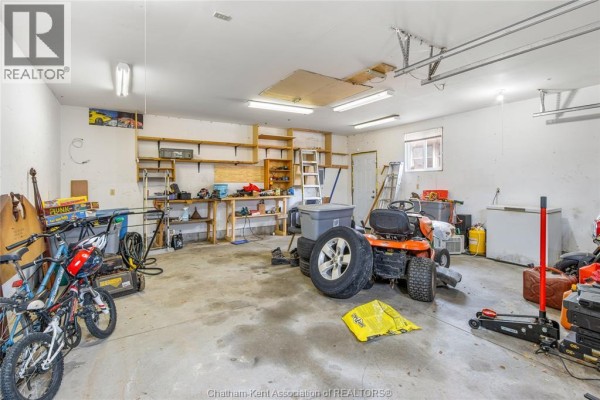 Garage with lawn tractor, bikes, and shelving - 410 Mcnaughton Avenue East Chatham