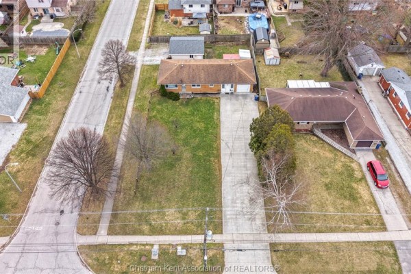 Single-family home with attached garage and red car - 410 Mcnaughton Avenue East Chatham