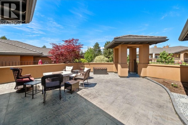 Outdoor patio seating area with furniture, fire pit, and architectural entrance feature. - 4100 Gallaghers Parkland Drive Unit# 16, Kelowna