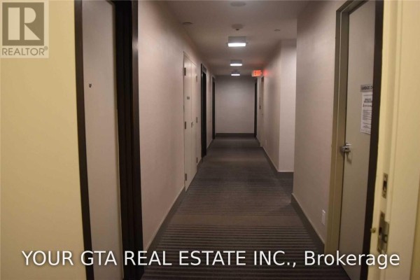 Long apartment hallway with multiple doors and striped carpet. - 4107 - 4011 Brickstone Mews, Mississauga