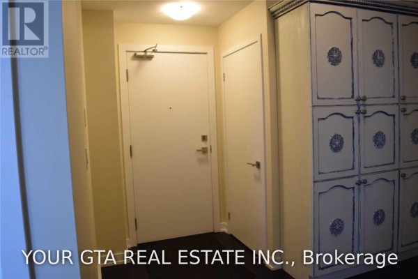 Apartment entrance foyer with white doors and a tall white cabinet with decorative blue accents. - 4107 - 4011 Brickstone Mews, Mississauga