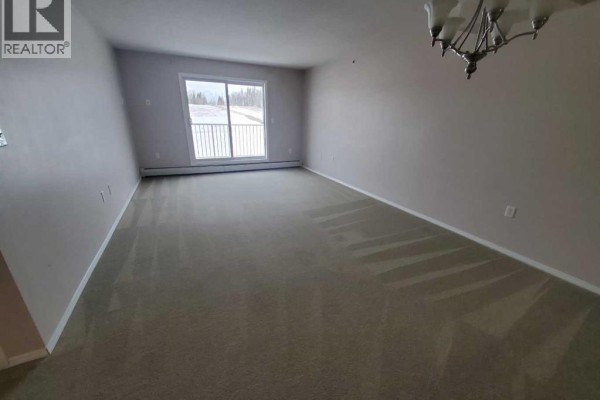 Spacious living room with carpet flooring and sliding glass door to balcony - 411, 1615 41 Street, Edson