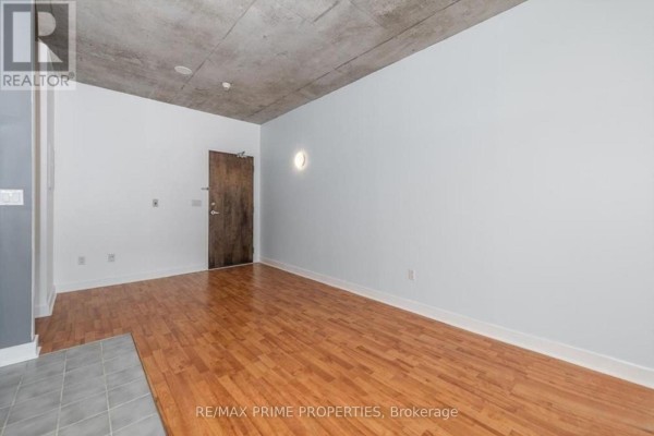 Bright bedroom with large windows, hardwood flooring, and sliding closet doors - 411 - 383 Cumberland Street, Ottawa