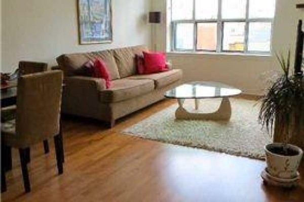 Living room with brown sofa, glass coffee table, and hardwood floors. - 412 - 438 Richmond Street W, Toronto