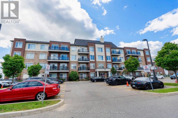Front view of a brick apartment building with balconies and a parking lot. - 412 - 54 Sky Harbour Drive, Brampton