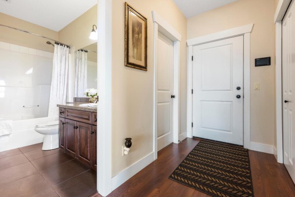 View of a bathroom with a white tub, vanity, toilet, and dark tile flooring. - 412 45893 Chesterfield Avenue, Chilliwack Downtown, Chilliwack