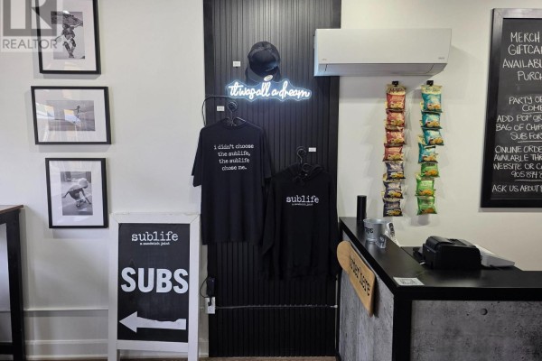Interior retail display with t-shirts, hats, snacks, and a checkout counter. - 412 Derby Road, Fort Erie