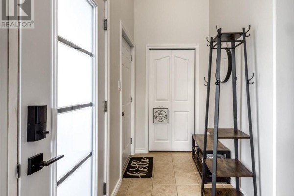 Interior entryway with tile flooring, coat rack, and white doors. - 4120 Heritage Drive, Hanmer