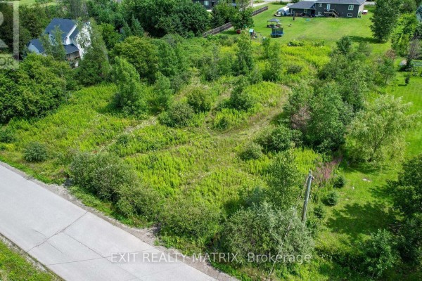 Snow-covered terrain with patches of trees and residential properties in the background. - 4123 Calbrent Way, Ottawa