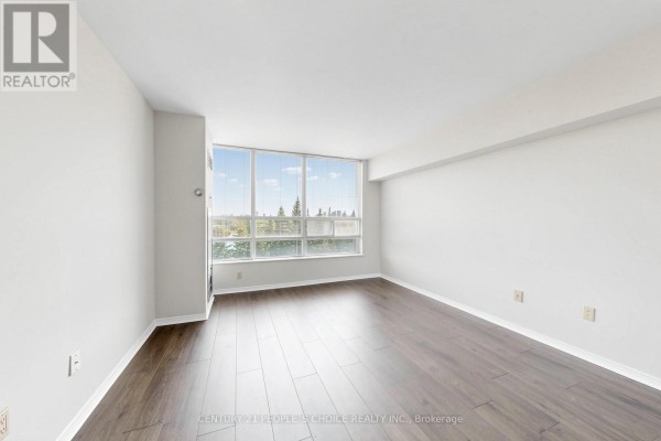 Empty living room with dark wood laminate flooring and a large window with a view. - #413 - 7805 Bayview Avenue, Markham
