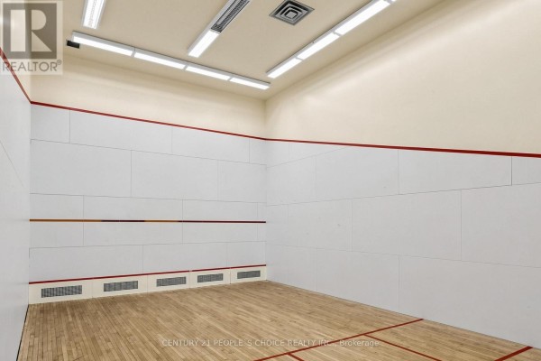 Empty squash court with white walls, red trim, and a wooden floor. - #413 - 7805 Bayview Avenue, Markham