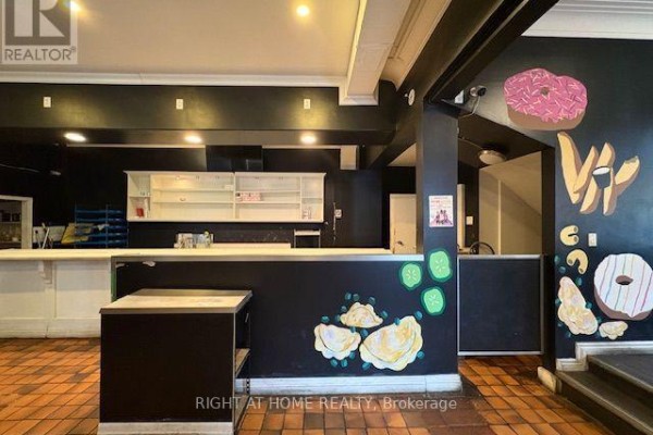 Interior counter area with display cases of food and a menu board on black wall. - 413 Hamilton Road, London East