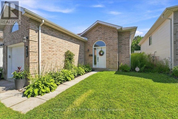 Front exterior of a brick home with a lawn and pathway to the arched entryway. - 413 Irwin Street, Midland