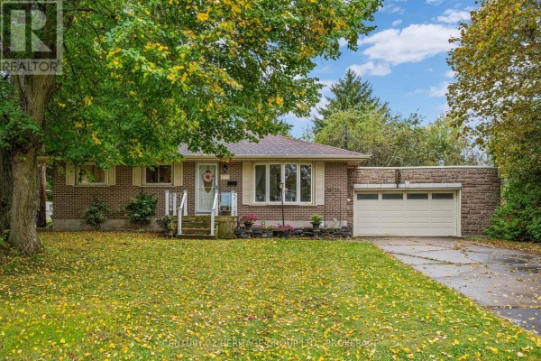 Front view of a brick bungalow with a lawn covered in fallen leaves. - 413 Maple Ridge Drive, Kingston