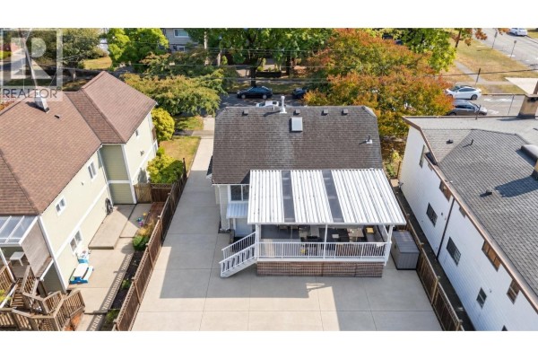 Aerial view of the rear exterior of the house showing a covered patio and driveway. - 413 Seventh Avenue, New Westminster