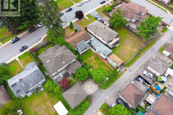 Wide aerial view of a suburban neighborhood with office buildings and skyline. - 4137 Dominion Street, Burnaby