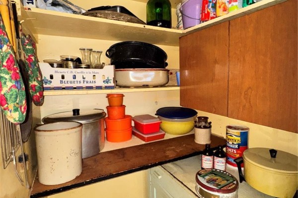Kitchen with white cabinets, a sink, beige patterned wallpaper, and a ceiling fan. - 414 4th Avenue E, Biggar