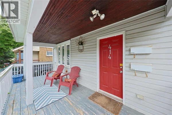Front porch with red door, two chairs, and mailboxes. - 414 Davis Street, Sarnia