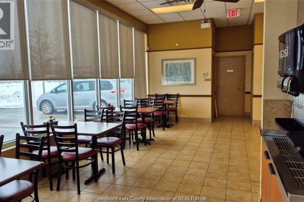 Counter area with food containers, stacked plates, and a Pepsi refrigerator in a commercial setting. - 4140 Walker Road Unit# 200-101, Windsor