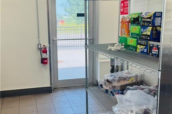 Interior view of storage area with shelves stocked with drinks and supplies. - 4140 Walker Road, Windsor