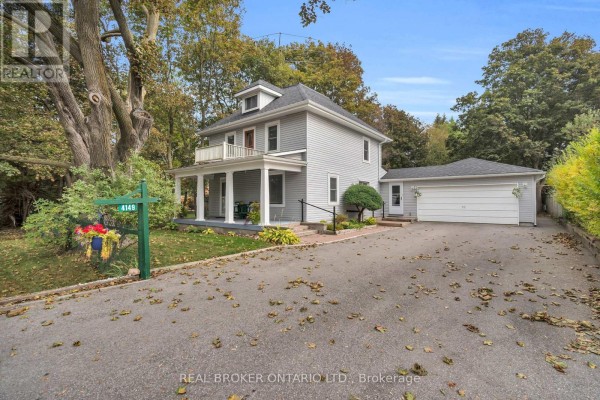 Grey house with covered porch, balcony, detached garage, and a street sign reading 4146. - 4149 Front Street, Uxbridge