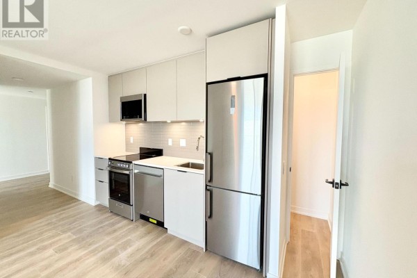 Modern kitchen with stainless steel appliances and light grey cabinetry. - 415 - 1 Vine Avenue, Toronto