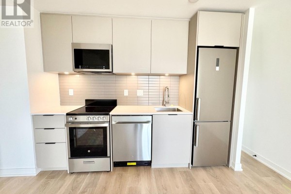 Close-up view of a modern kitchen with stainless steel appliances and grey cabinets. - 415 - 1 Vine Avenue, Toronto