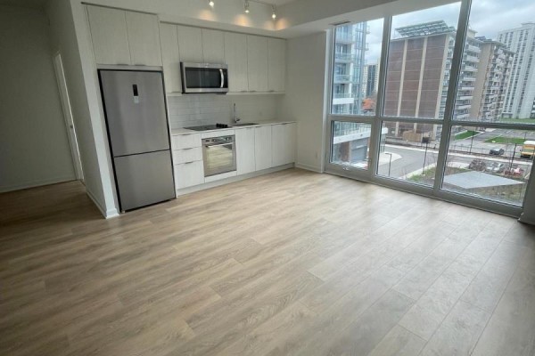 Spacious living area with kitchen, large windows, and a view of the surrounding buildings - 415 - 38 Forest Manor Road, Toronto