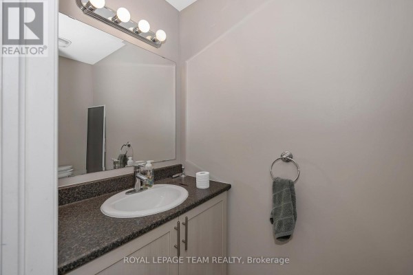 Powder room with a sink, vanity, toilet, and towel ring. - 415 Arncliffe Avenue, Ottawa