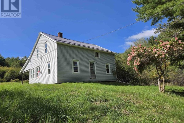 Front view of a light blue two-story house with white trim and a metal roof. - 415 Old Harmony Road, Harmony Mills